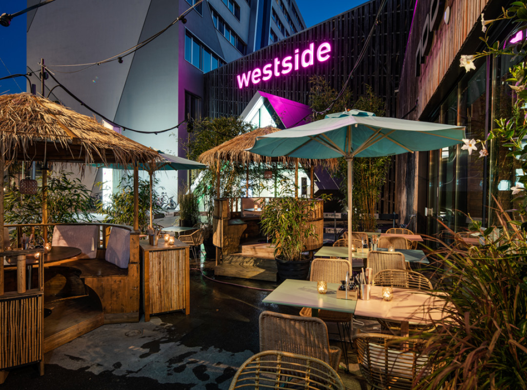 Terrasse vor dem Restaurant beim Einkaufszentrum Westside in Bern, geniesse unsere tropische Terrasse mit Sonnenschirmen direkt in Bern.